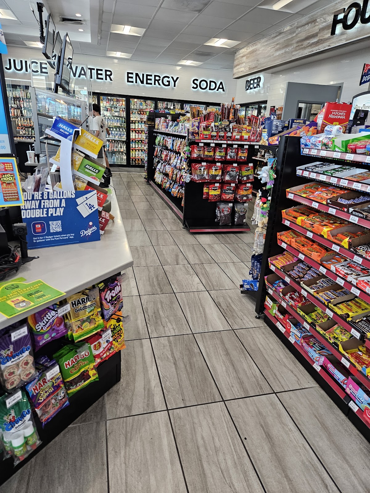 Aisle inside Chuck's with juice, water, energy drinks, and snacks